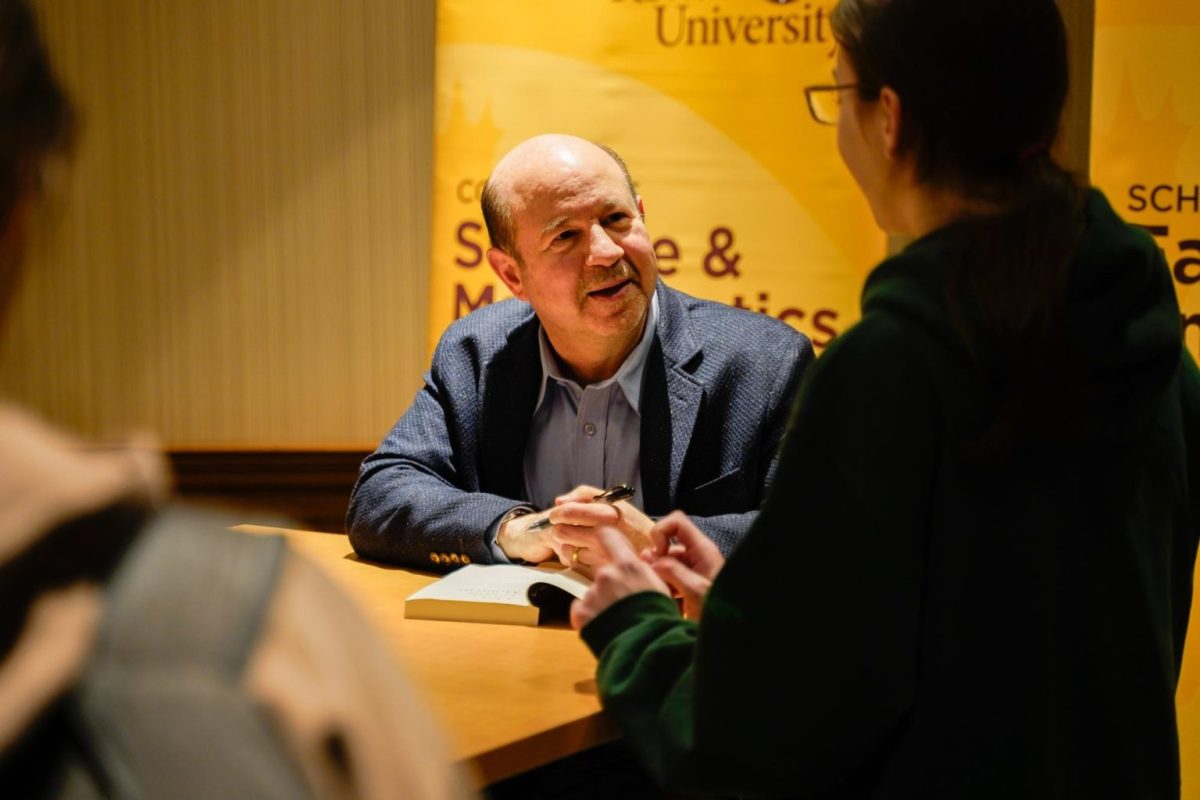 Michael Mann talks to a student while signing a copy of his book in the Chamberlain Student Center. Glassboro, NJ. Monday, Feb. 24, 2025. (Gavin Schweiger)