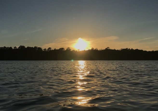 The sun sets over the Mullica Watershed, with warm colors reflecting off the calm waves. The watershed area is one of the locations regularly cleaned up by Go Green Galloway. (Jayna Petrosh)