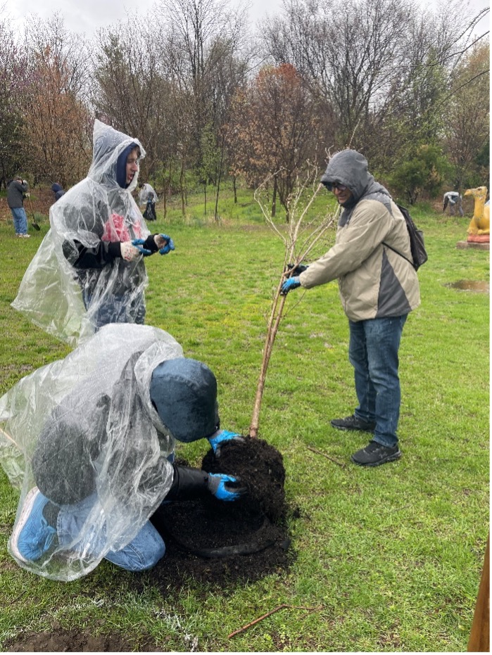 Rowan University undergraduate students Ike Brecker Gross and James King, along with Dr. Mahbubur Meenar, plant a tree in Camden’s Waterfront South neighborhood. (Courtesy of Megan Polifrone)
